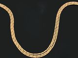 a gold necklace on a black background with a black background