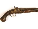un vieux pistolet avec une poignée en bois sur une surface blanche