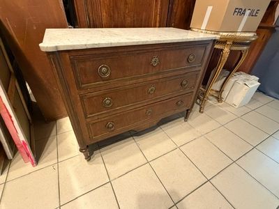 a dresser with a marble top in the middle of a room