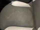 a dirty seat of a car with a black and white seat cover