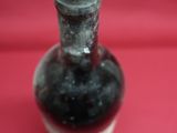 a bottle of wine sitting on a red cloth