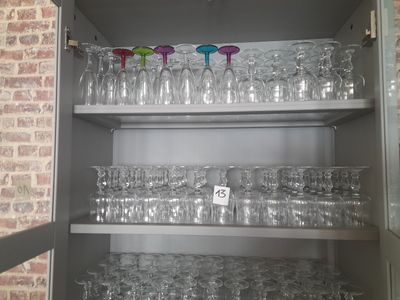 de nombreux verres sur les étagères du placard