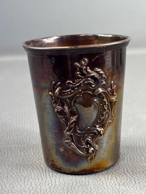 a silver cup with a picture on it sitting on a table