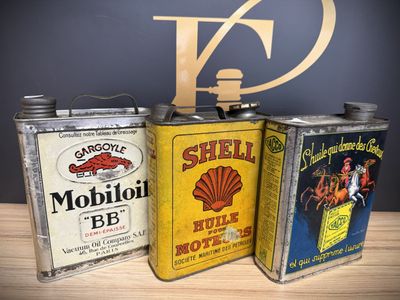 three cans of oil sitting on a table next to each other