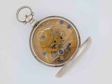 a pocket watch that is sitting on a white surface