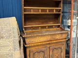 une armoire en bois avec une porte vitrée, devant laquelle se trouve une chaise