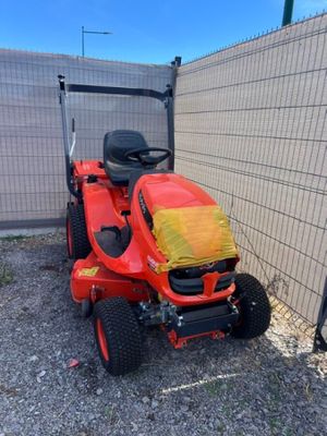 une photo d'une tondeuse à gazon rouge garée devant une clôture