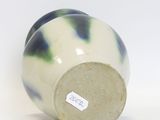 a blue and white vase sitting on a white surface