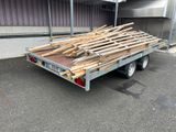 une remorque chargée d'une grande quantité de bois à l'arrière