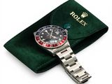 the rolex watch is sitting on a green velvet case