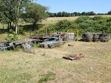 a lot of junk in a field with trees in the background