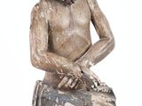 a wooden statue of a man with a suitcase