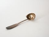 a spoon that is sitting on a white surface