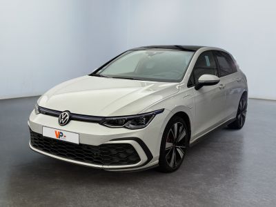a white volkswagen golf r - line parked in a white room