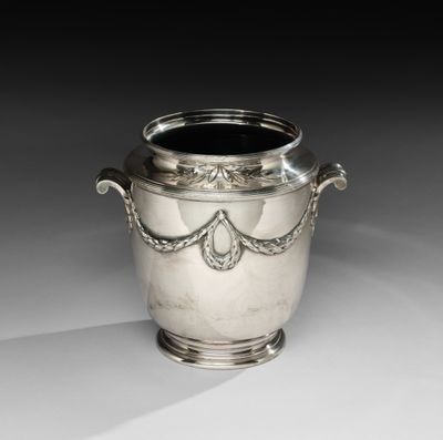 une image représentant un vase en argent posé sur une table