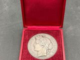 a silver coin in a red box on a table