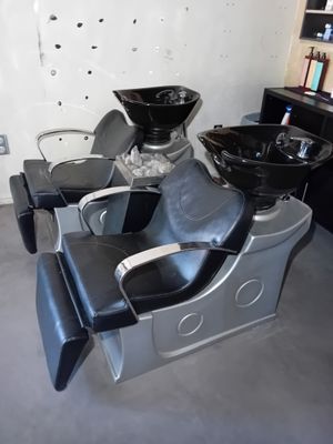 une chaise noire et argentée dans une pièce équipée d'un lavabo et d'un miroir