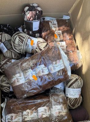 many balls of yarn in a box of brown and white yarn
