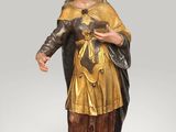 a statue of a man in a golden outfit holding a cross