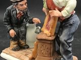 a figurine of a man and a man pouring water