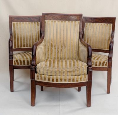 two wooden chairs with striped upholstered seats against a white wall