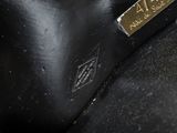 a close up of a black bag with a gold label on it