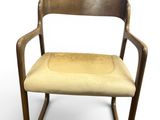 an image of a wooden chair with a beige seat and armrest