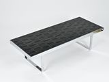 a black and white coffee table with a metal base and a black tile top