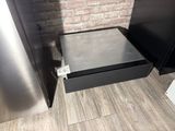 a metal drawer with a metal lid in the corner of a kitchen