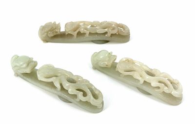 four pieces of jade carved hair clips on a white surface