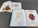 three books that are open on a table