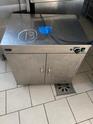 a stainless steel box with a blue handle on the floor