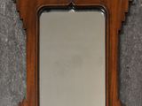 a wooden mirror hanging on the wall next to a wall
