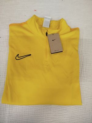un polo Nike jaune avec une étiquette dessus