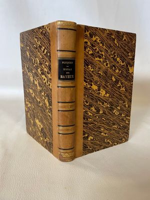 an old book sitting on top of a white cloth covered table