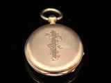 a gold pocket watch with a number one engraved on it