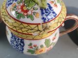 a small teapot with a lid on a table