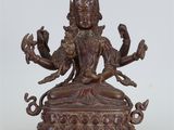 une statue en bronze représentant une femme assise sur une table