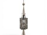 un objet métallique argenté surmonté d'une haute tour