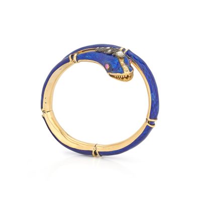a close up of a gold ring with a blue snake on it