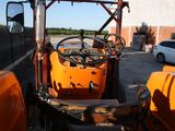 an orange tractor that is parked in a parking lot