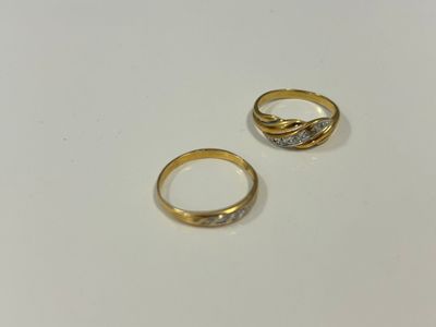 deux bagues en or serties de diamants, posées sur une surface blanche