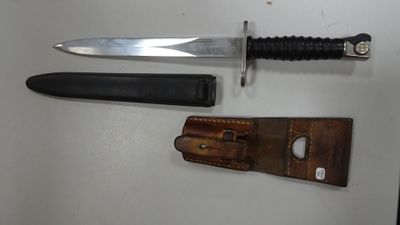 un couteau posé sur une table à côté d'un portefeuille