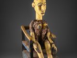 une image représentant une sculpture en bois d'un homme assis sur une chaise
