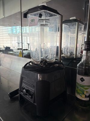 a blender sitting on a counter next to a bottle of alcohol