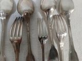 cinq cuillères en argent et deux cuillères en argent sur une table