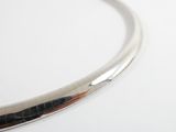 a close up of a silver necklace on a white surface
