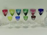 de nombreux verres à vin et carafes de différentes couleurs sur la table