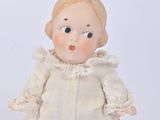 a small doll that is standing on a white surface