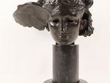 sculpture of a woman ' s head with wings on a marble base